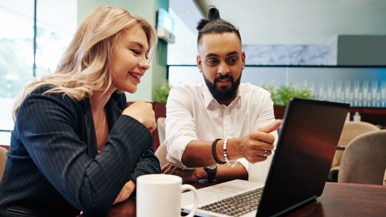 man and woman having a meeting looking at computer